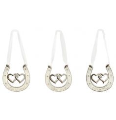 An assortment of three silver plated horse shoes with wedding text