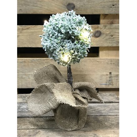 An authentic looking frosted topiary ball with hessian sack and pretty lights.