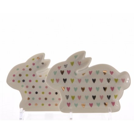 A mix of two rabbit shaped plates in multi-coloured heart and polkadot designs.