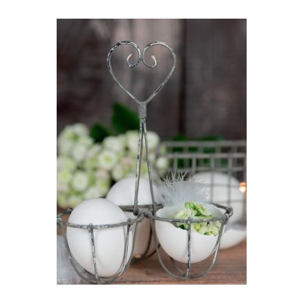 A rustic style egg holder with a decorative heart handle.