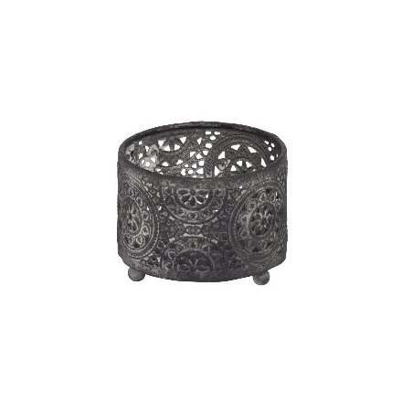 A decorative metal t-light holder with a rustic finish and a decorative pattern.