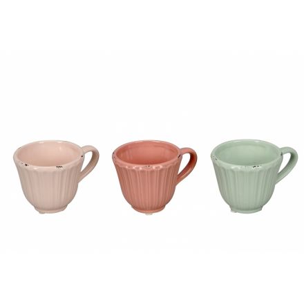 An assortment of 3 pastel coloured teacups each with a shabby chic finish.