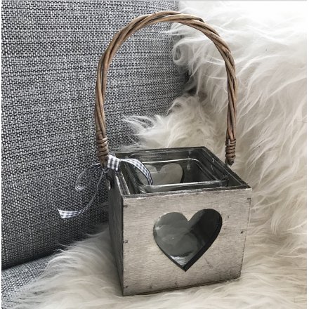 A charming wooden lantern with a heart design, rattan handle and a chic grey gingham bow.