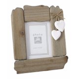 A shabby chic style wooden photo frame with two hanging hearts.