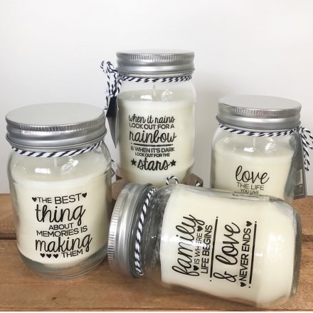 An assortment of 4 candles in glass jars with mottos