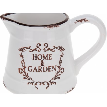 A shabby chic style ceramic jug with a distressed finish and Home & Garden slogan.