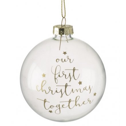 A beautifully delicate clear glass baubles finished with a golden script "Our First Christmas Together"
