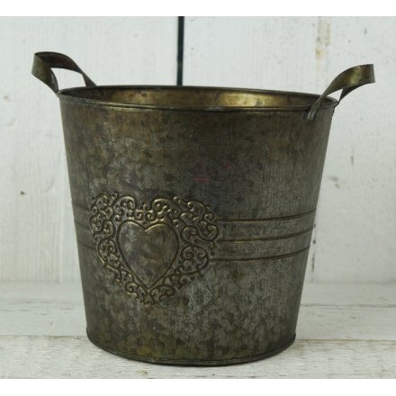 A large copper round planter with heart design