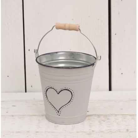  Set with its grey wash tone and added heart decal, this decorative metal bucket will look beautiful with artificial blo