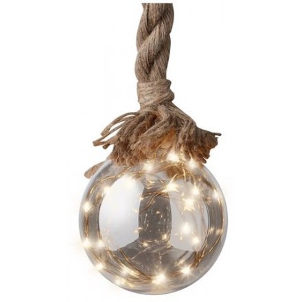 A smoked grey glass bauble hung from a chunky rope hanger and filled with a warm white LED glow 