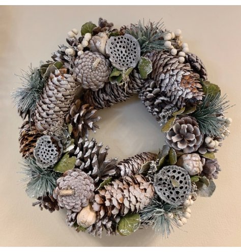 A full Christmas wreath with white berries, pinecones and natural foliage. 
