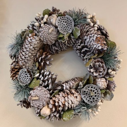 A full Christmas wreath with white berries, pinecones and natural foliage. 