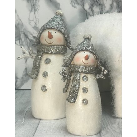 Bring a Winter Wonderland edge to your home decor this Christmas season with this sweetly decorated resin based snowman 