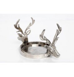 A silver tone iron candle holder with double stag head design