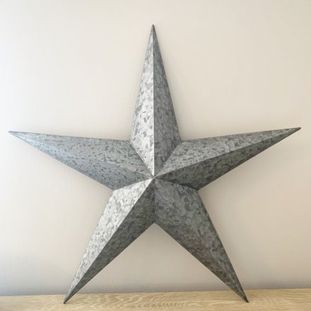 A large metal barn star with a hammered, distressed finish and 3-dimensional points. 
