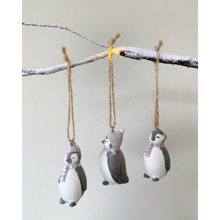 An adorable little trio of resin penguin figures each coated in a sprinkle of glittery snow 