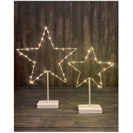 A shabby chic white standing star wrapped with warm glow LED lights.