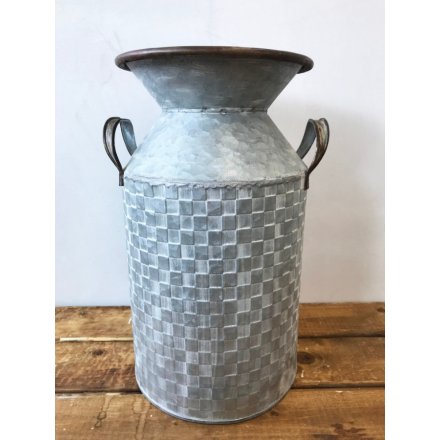A rustic zinc metal churn with twin handles and a textured square tile pattern.