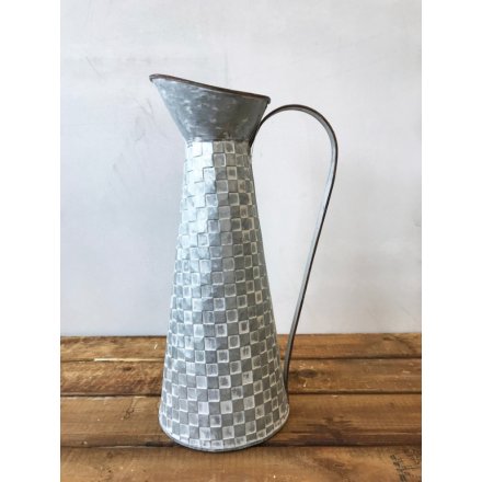 A rustic style zinc jug with a unique patchwork pattern. A chic decoration and vase.