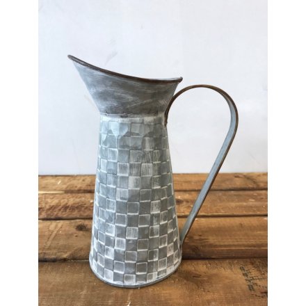 A rustic style metal jug with a textured square tile pattern.
