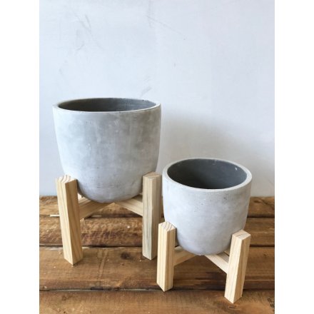 A contemporary style concrete planter set upon a modern wooden stand.