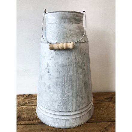 A rustic zinc churn with a wooden handle and a distressed finish.