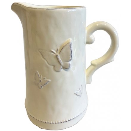 A charming cream ceramic jug with butterfly decorations. 