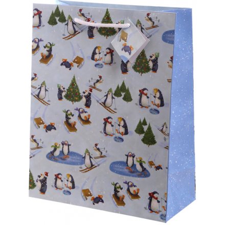 a glossy gift bag covered with wintery penguins enjoying the snow 