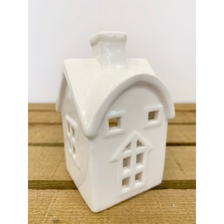   A simple white toned ceramic house decoration with an added tlight holder space 