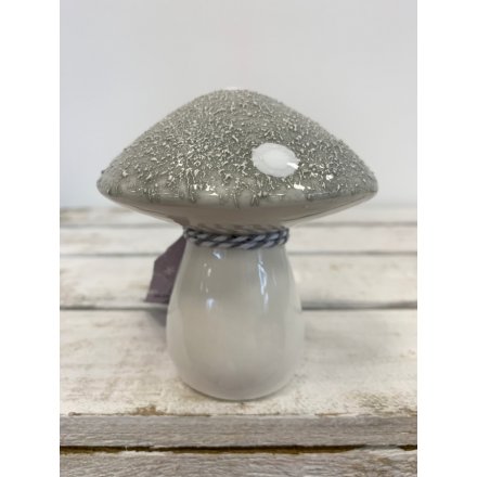 A small ceramic mushroom with an added rough grey top and dotted decal 