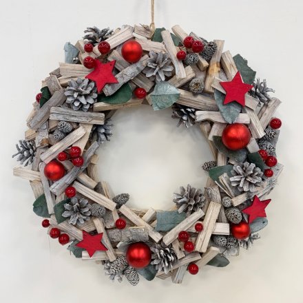 A beautifully traditional themed wooden wreath built up of red baubles, stars, berries and pinecones 