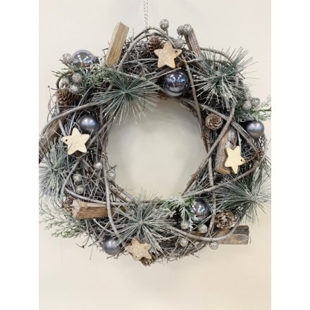 A beautifully decorated pine wreath with added wooden accents and grey baubles 