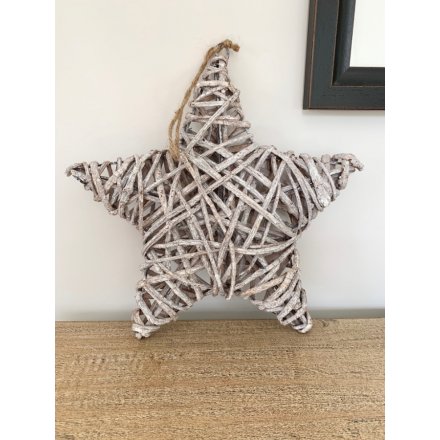 A large hanging grey toned star made up of rustic woven rattan and hung from a jute string 