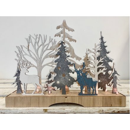 A sparkling winter wonderland featuring a woodland scene with reindeer and frosted trees.