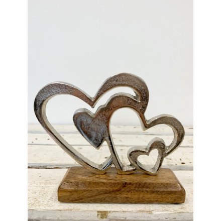 A rough luxe silver heart ornament with chunky wooden base. 