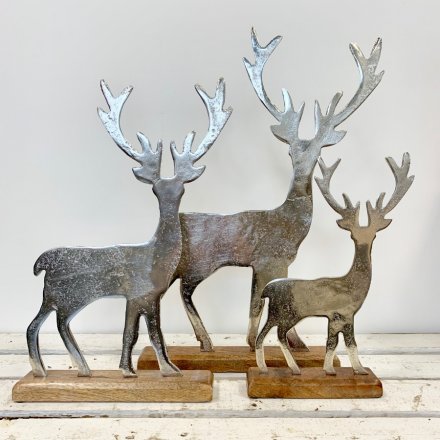 A rustic silver aluminium stag set upon a natural, chunky wooden block.