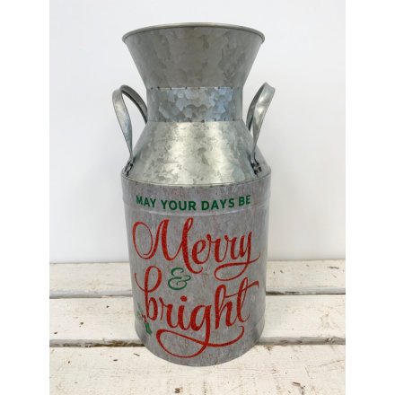 A festive milk churn with a red glitter Christmas slogan.