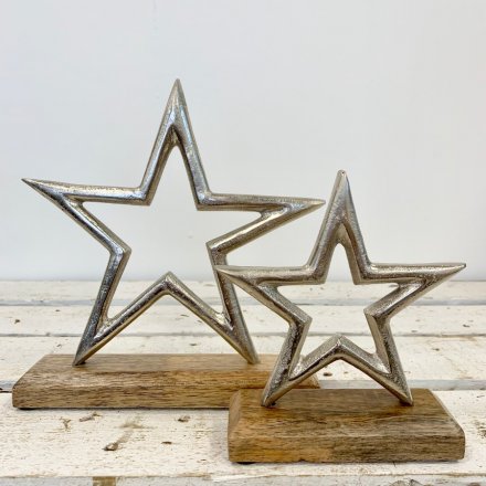 A rustic style aluminium star decoration set upon a chunky wooden base.