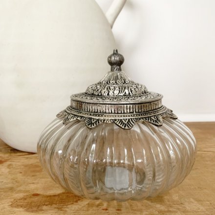  A clear ridged glass jar featuring a distressed metal lid with added embossed decals 