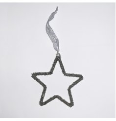 A festive themed hanging glittery star covered with silver beads and hung by a ribbon