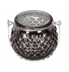 A small round ridged glass tlight holder set with a mottled silver centre and smoked grey tone