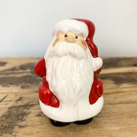An assortment of small posed ceramic Santa characters, dressed up in festive red colours 