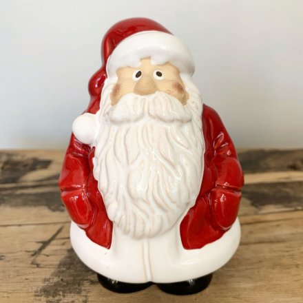Cute and quirky jolly Santa figurines in shiny red and white suits with black polished boots.