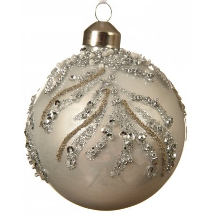 A warm winter white matt bauble with gold and silver glitter and beading in a branch design.