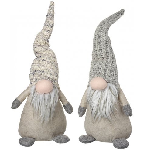 An assortment of standing fabric gonks. Each has a knitted hat in grey and natural colours