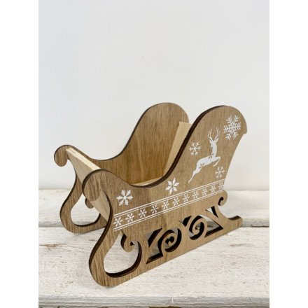 A wooden sleigh Christmas centre piece with a white reindeer and snowflake design