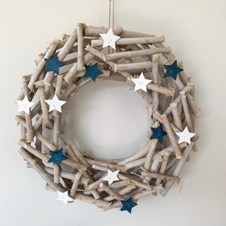 A large round wreath built up of assorted sized twigs and decorated with red and blue coloured wooden stars 