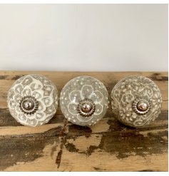 A stylish mix of ceramic doorknobs featuring intricate cream and white patterns 