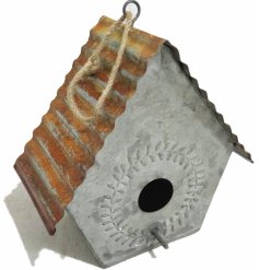 A rustic metal hanging bird house complete with a rusted ribbed roof 