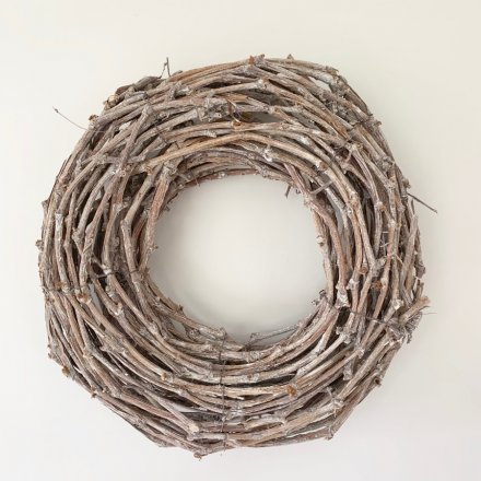 A charmingly simple round wreath built up of woven twigs in a grey tone 
